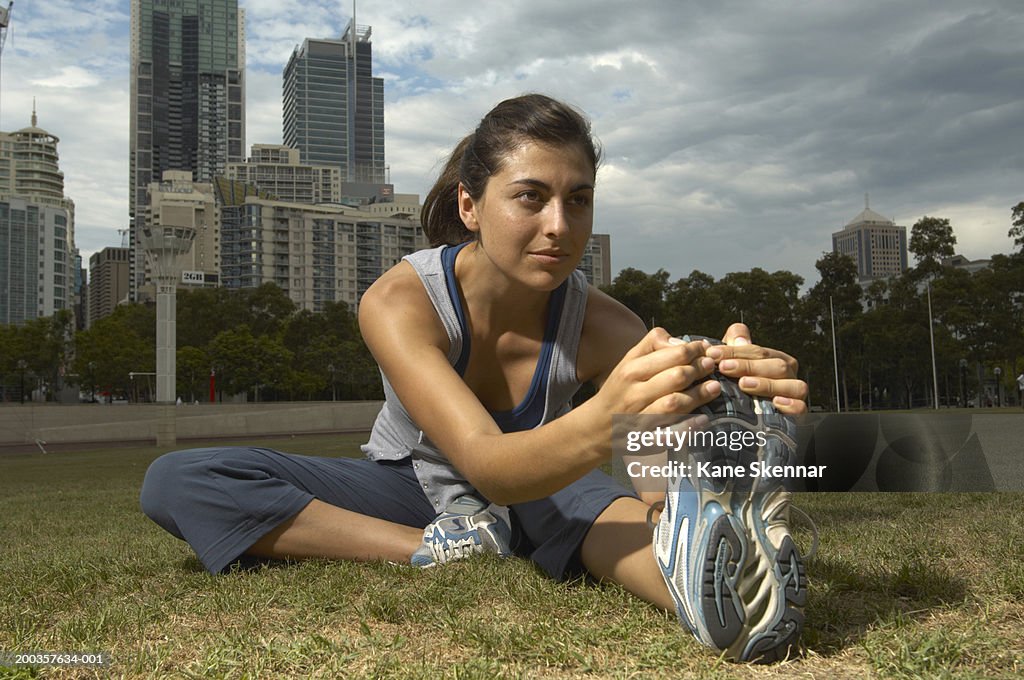 Young woman touching toes, close up