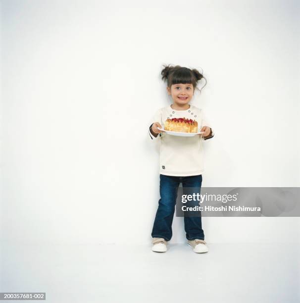 girl (4-5) holding cake, smiling, portrait - japanese ethnicity the human body stock pictures, royalty-free photos & images