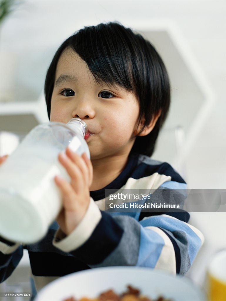 Boy (3-4) drinking milk from bottle