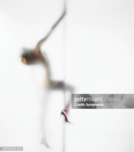 naked young woman pole dancing, side view (defocussed) - pole dancing heels photos et images de collection