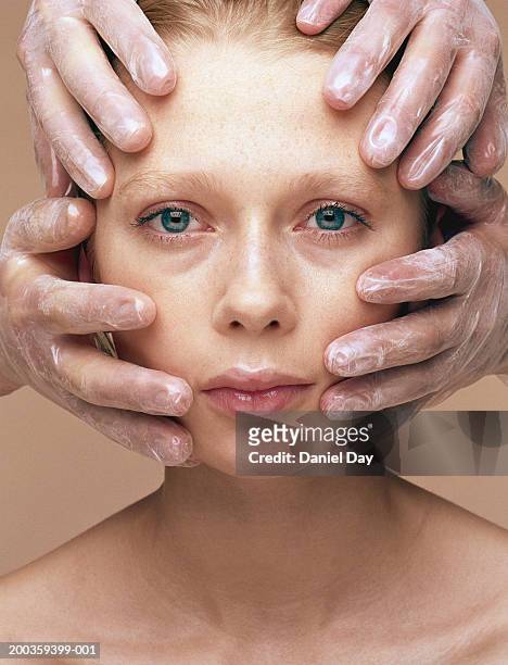 two people with gloved hands touching young woman's face - chirurgia estetica donna foto e immagini stock