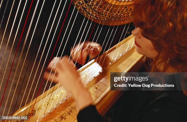 woman playing harp (blurred motion) - arpa fotografías e imágenes de stock