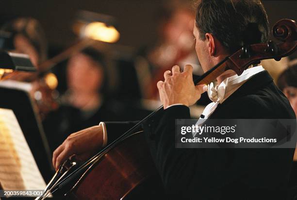 male cellist playing in orchestra - musica clássica imagens e fotografias de stock