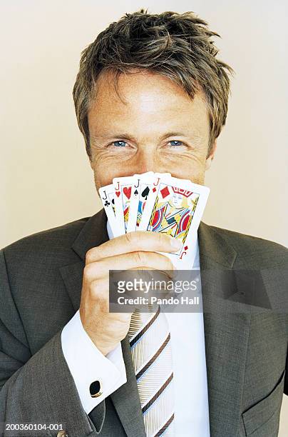 businessman with four knaves playing cards in front of mouth, portrait - portrait holding card foto e immagini stock