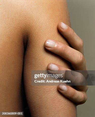 Woman touching arm, close-up Woman touching arm, close-up