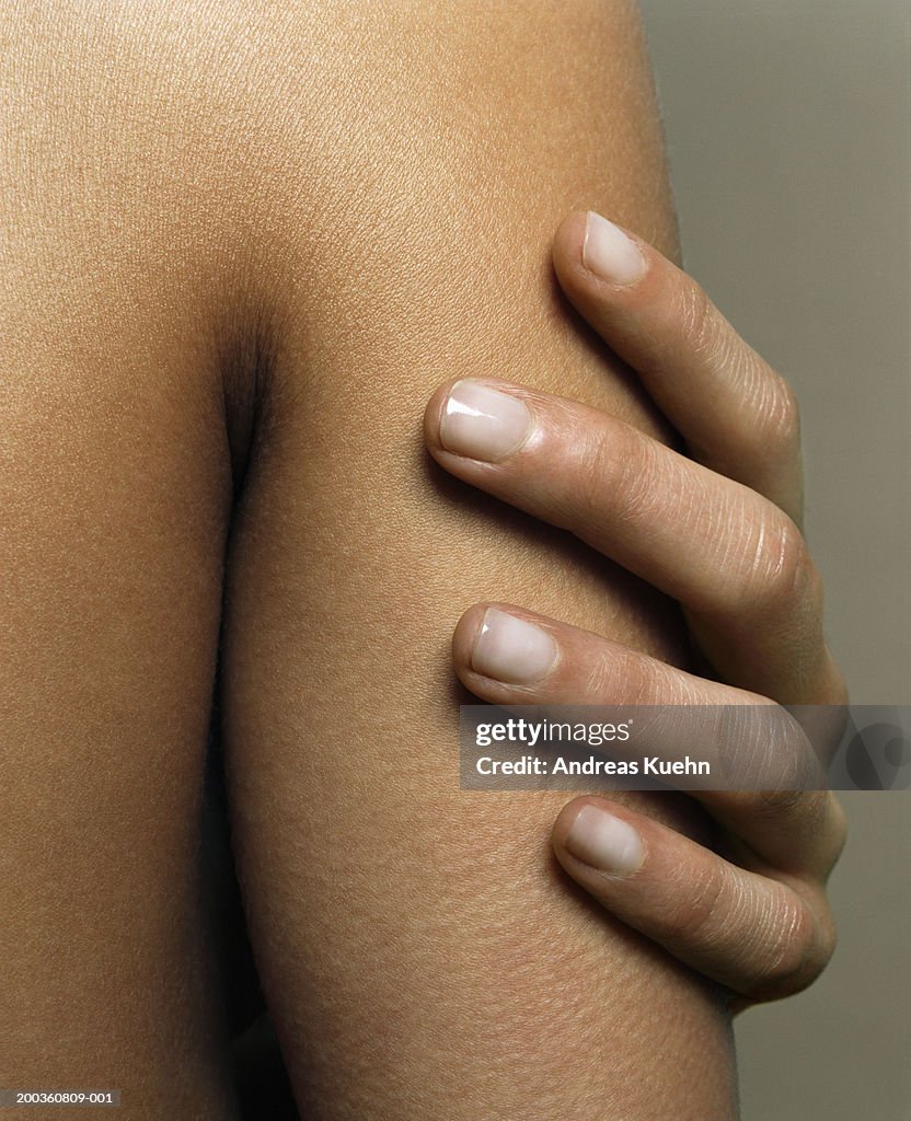Woman touching arm, close-up