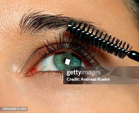 Woman applying eyelash makeup, close-up Woman applying eyelash makeup, close-up