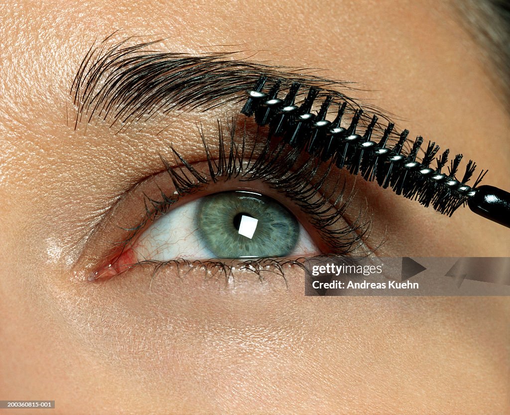 Woman applying eyelash makeup, close-up