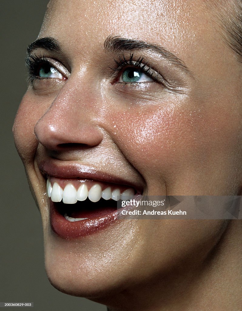 Young woman laughing, looking upwards, close-up