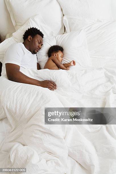 baby girl (8-11 months) sleeping on bed with father - black man sleeping in bed stock pictures, royalty-free photos & images