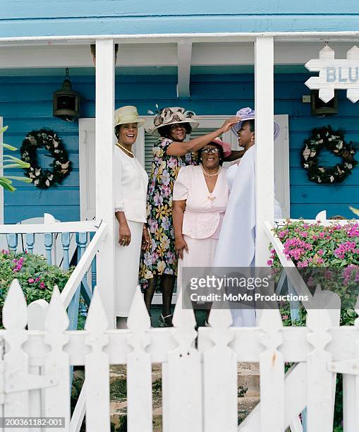 mature and senior women on porch wearing hats and dresses - cappellino da signora foto e immagini stock
