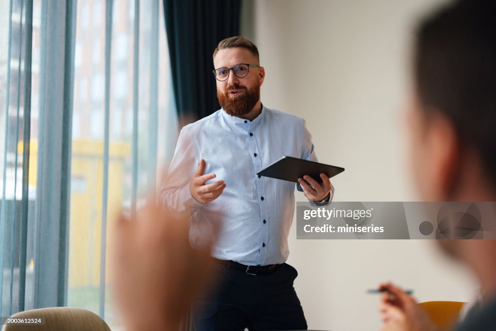 Confident Businessman Presenting Ideas at Office Meeting
