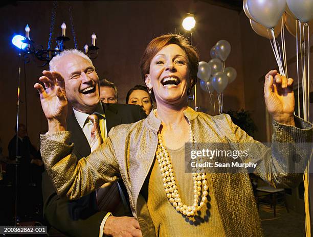 mature couple leading conga line on dance floor - conga stock pictures, royalty-free photos & images