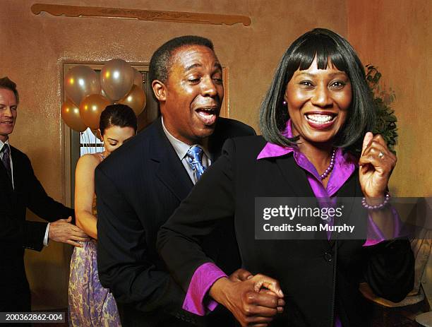 mature couple joining conga line on dance floor - conga stock pictures, royalty-free photos & images