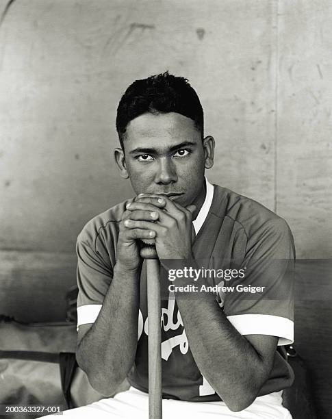 baseball player leaning on bat, portrait (b&w) - baseball stock pictures, royalty-free photos & images