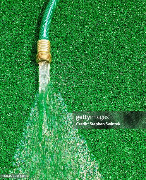 hose running water on artificial grass - garden hose foto e immagini stock
