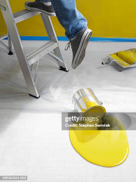 man climbing ladder, spilled paint on floor - farbeimer stock-fotos und bilder