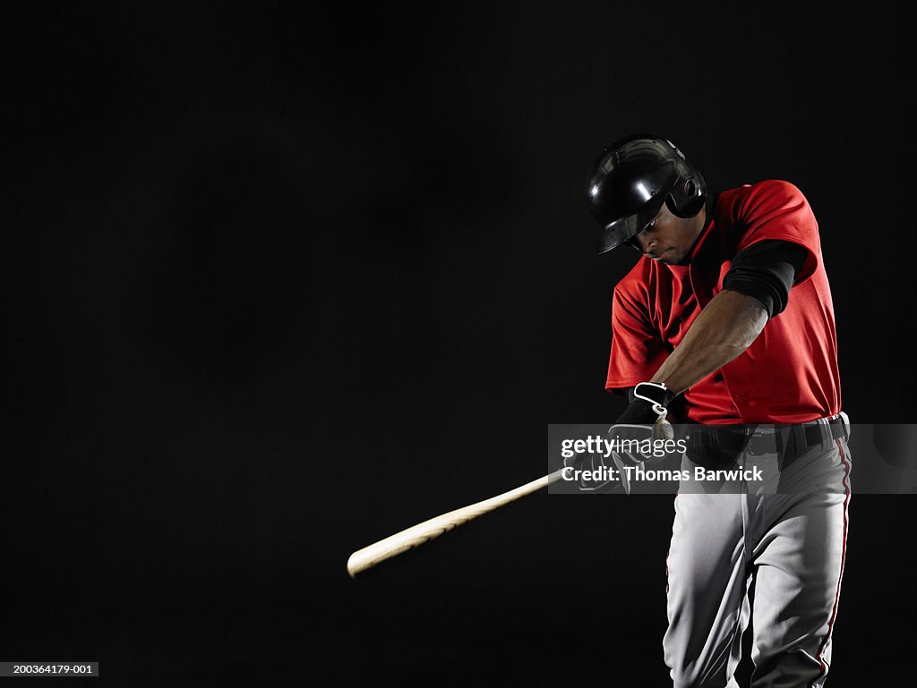 Young man swinging baseball bat