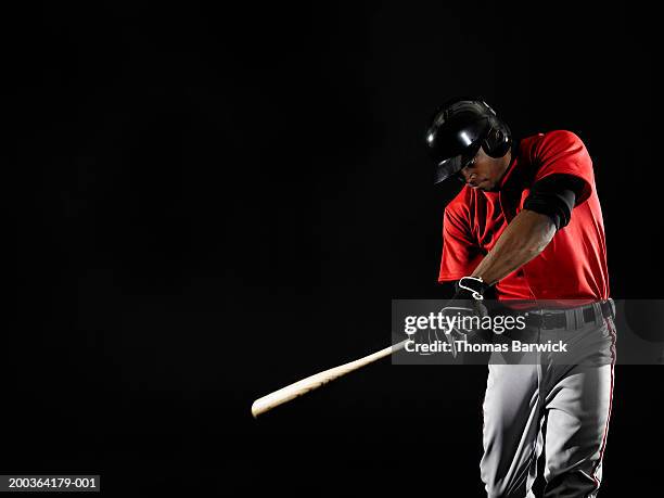 young man swinging baseball bat - divisa da baseball foto e immagini stock