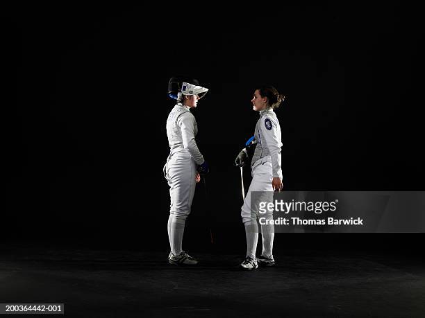 two female (15-18) fencers facing off, side view - face off sports play stock-fotos und bilder