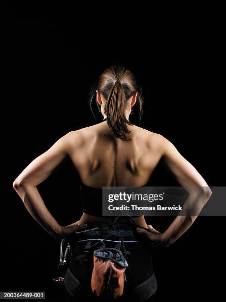 young female rock climber wearing harness, hands on hips, rear view - arms akimbo ストックフォトと画像