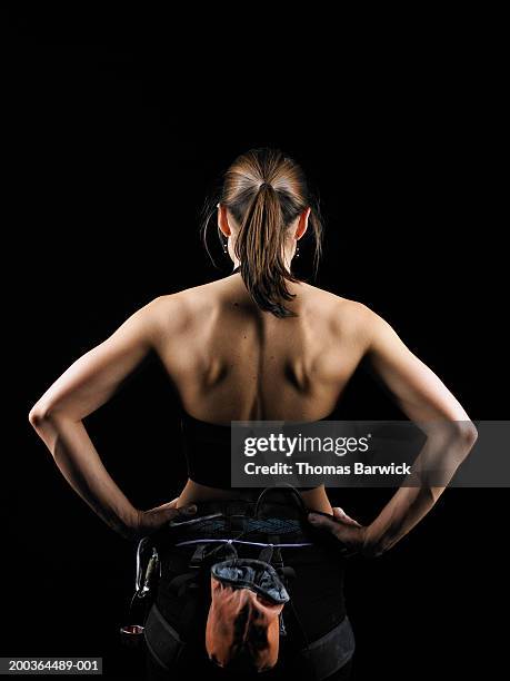 young female rock climber wearing harness, hands on hips, rear view - arms akimbo stock pictures, royalty-free photos & images