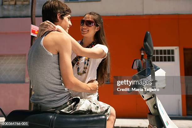 young couple embracing by moped - boyfriend girlfriend stock pictures, royalty-free photos & images