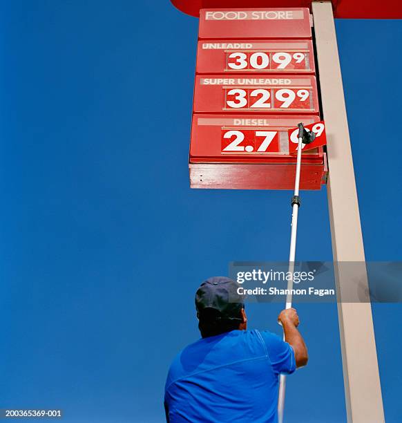 man putting up price sign at station, rear view - preisschild stock-fotos und bilder