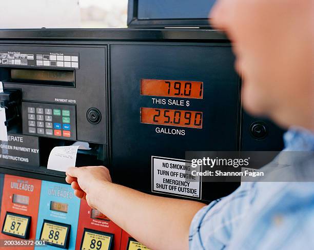 man getting receipt from gas pump - petrol paying stock-fotos und bilder