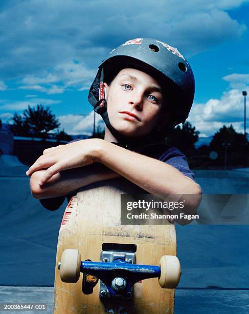 boy (10-12) wearing helmet with skateboard, portrait - boy 10 11 stock pictures, royalty-free photos & images