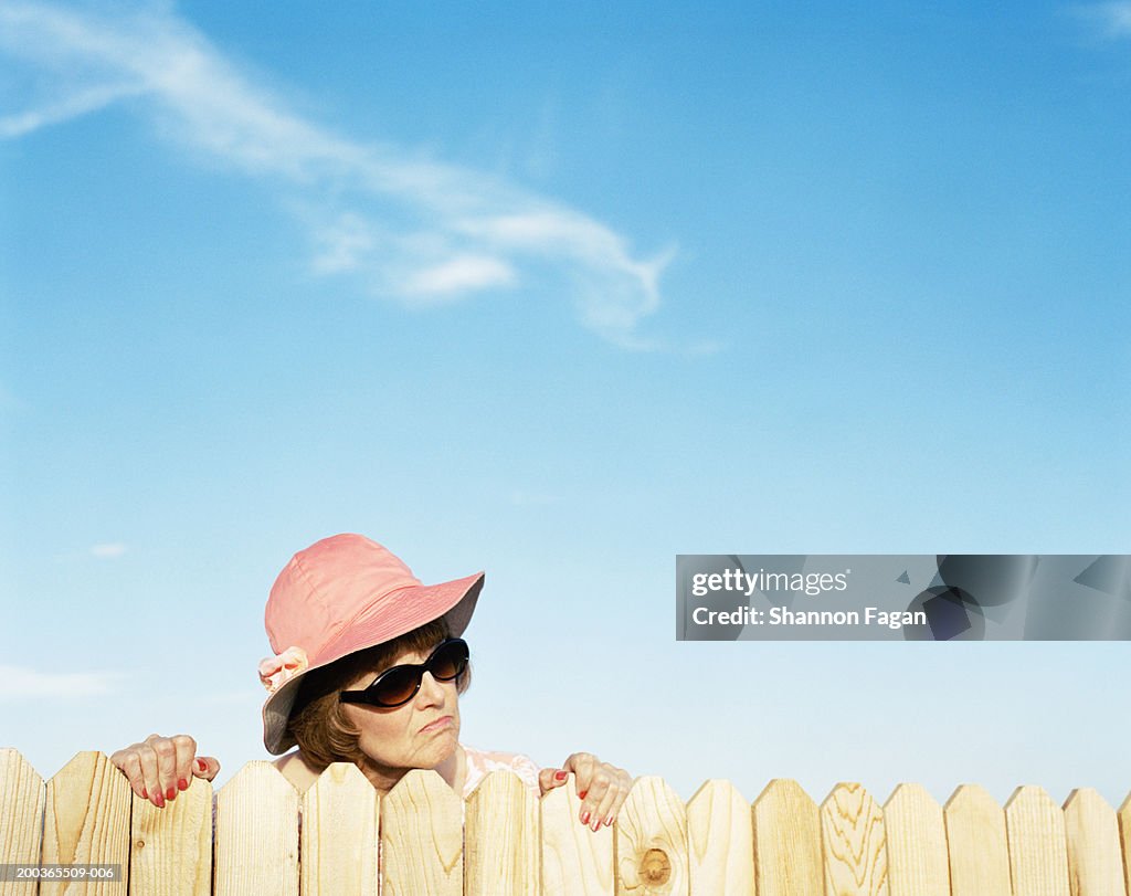 Mature woman looking over fence