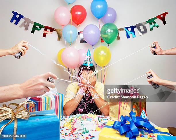 group of people spraying man with spray string - birthday stock pictures, royalty-free photos & images