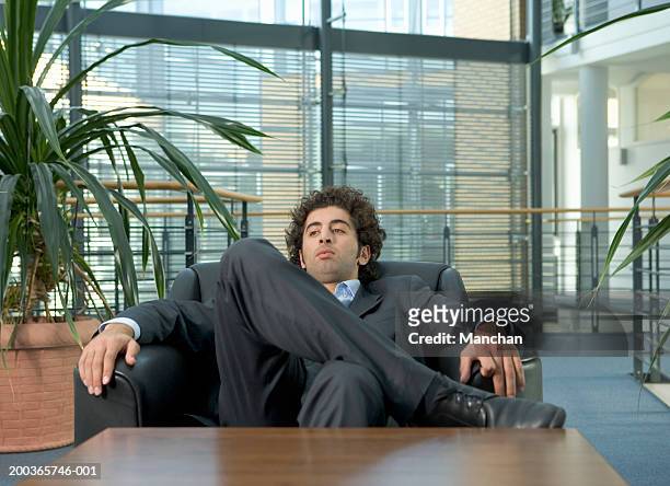 businessman reclining in armchair - verkeerde houding stockfoto's en -beelden