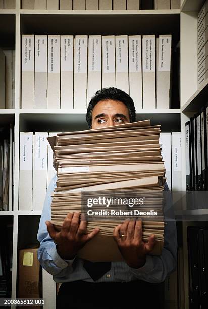mature businessman holding stack of files, looking sideways - exploitation stock pictures, royalty-free photos & images
