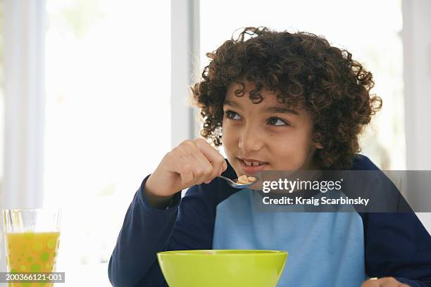 boy (8-10) at table, eating cereal - boy eating cereal stock pictures, royalty-free photos & images