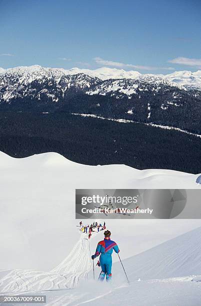woman heli skiing, whistler mountain, british columbia, canada, elevated view - heli skiing stock pictures, royalty-free photos & images
