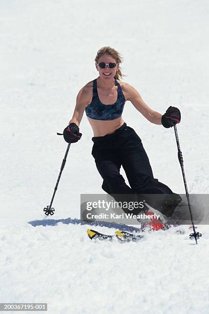 female skier in tank-top going downhill - ski pants stockfoto's en -beelden