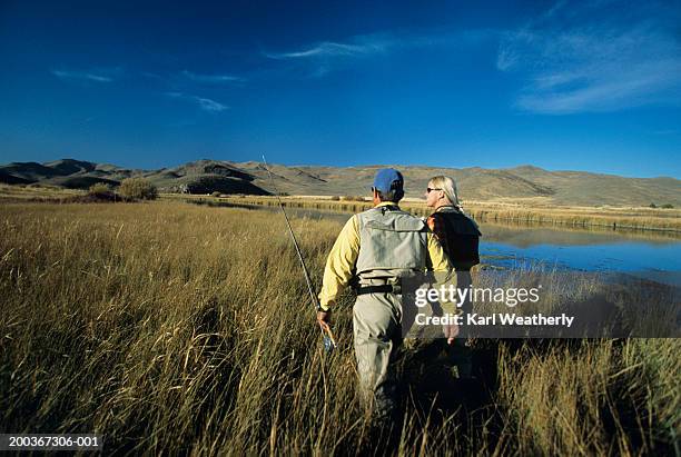 two fly fishers walking through tall grass - tall women stock pictures, royalty-free photos & images