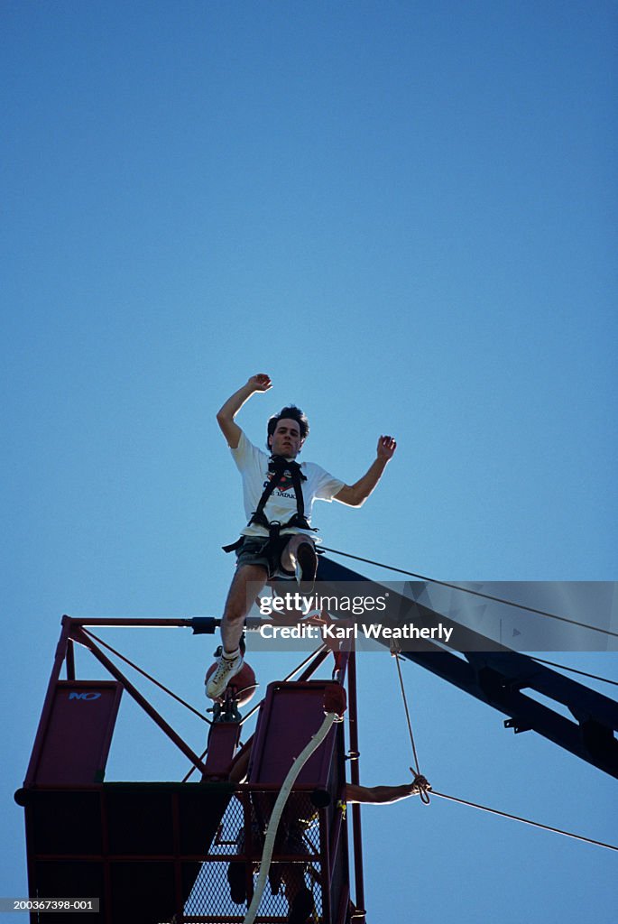 Man bungee jumping, low angle view