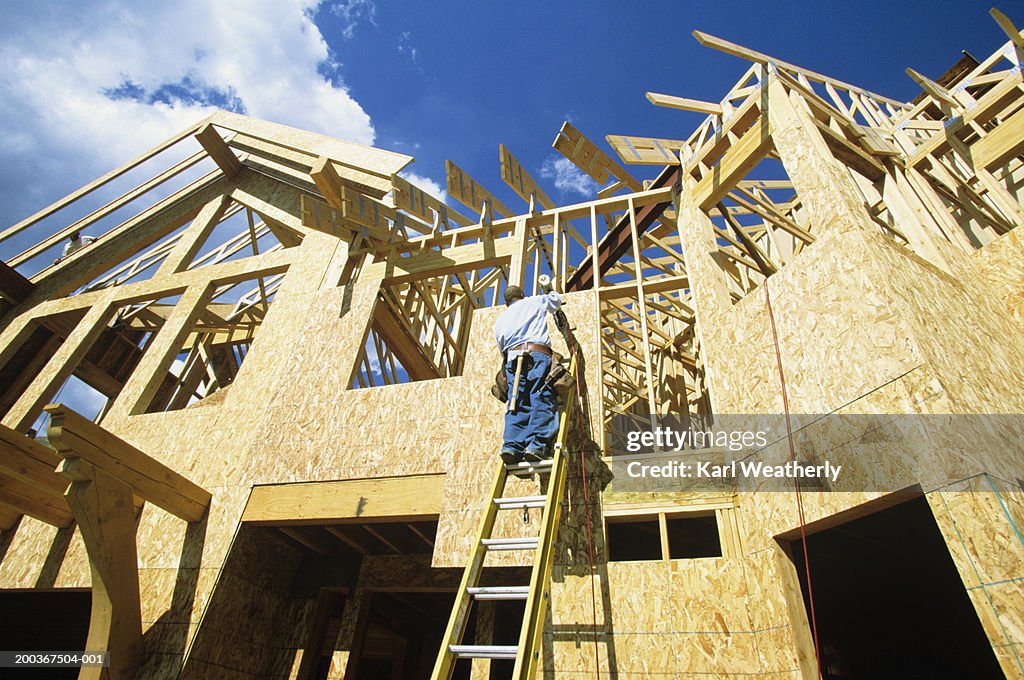 Man working at new home construction, low angle view