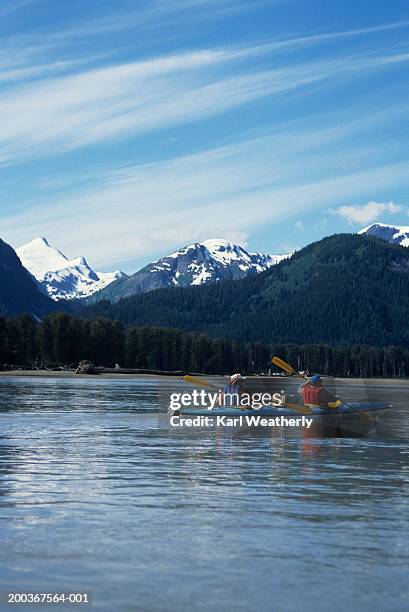 two people sea kayaking on stikine river, alaska, usa, rear view - stikine river stock pictures, royalty-free photos & images