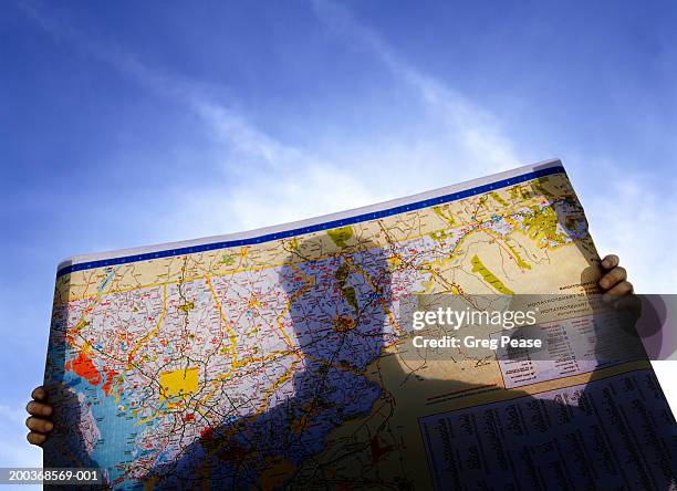 silhouette of man looking at road map (digital enhancement) - tourist map stock pictures, royalty-free photos & images