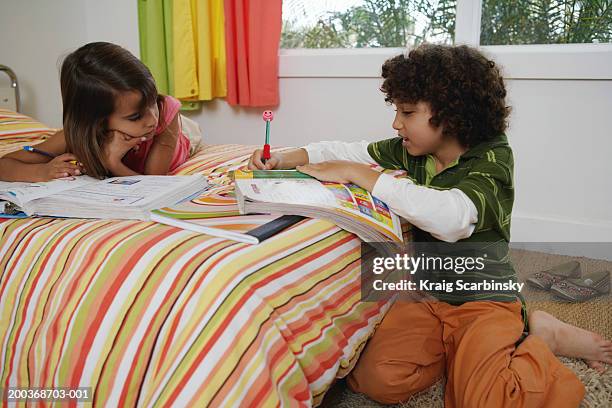 brother and sister (8-10) doing home-work on bed - bare feet kneeling girl stock pictures, royalty-free photos & images