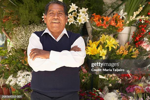 senior man standing at flower stall in street, smiling, portrait - flower stall imagens e fotografias de stock