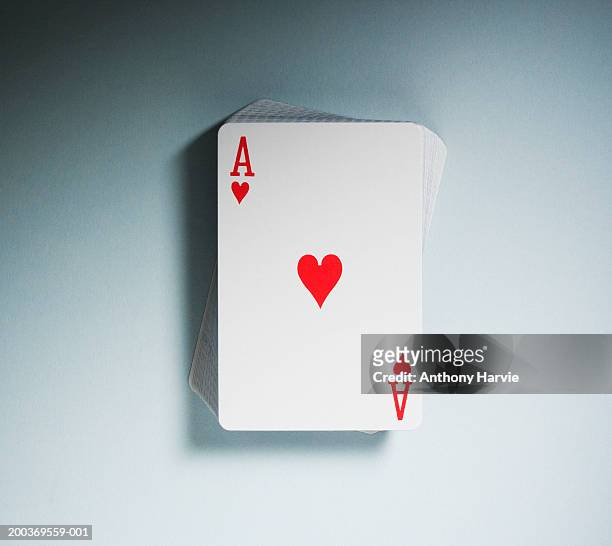 ace of hearts on top of pack of playing cards, close-up - ace of hearts stock pictures, royalty-free photos & images