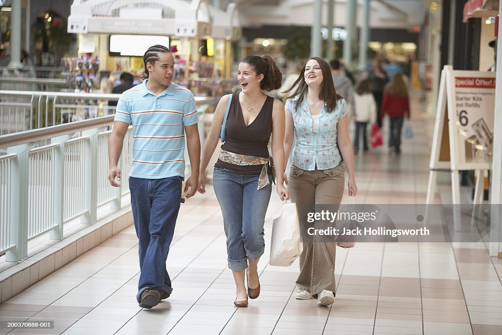 Two teenage girls and a teenage boy walking