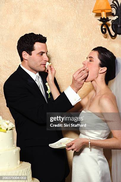 bride and groom eating wedding cake - naughty bride fotografías e imágenes de stock