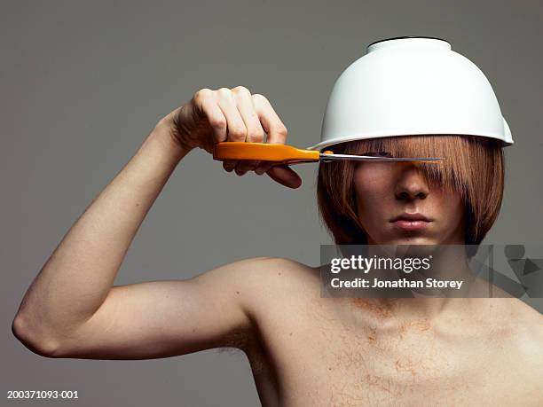 bare-chested man with bowl on head cutting fringe - pony haardracht stockfoto's en -beelden