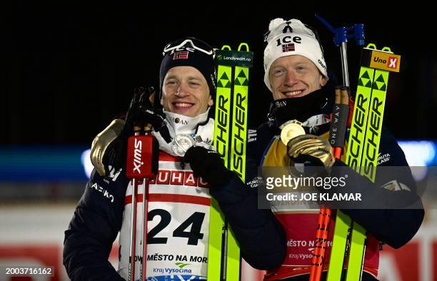 Second placed Norway's Tarjei Boe poses with his brother winner Norway's Johannes Thingnes Boe after the men's 20 km individual event of the IBU...