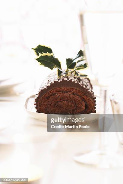 yule log on dining table decorated with holly - yule log stock pictures, royalty-free photos & images